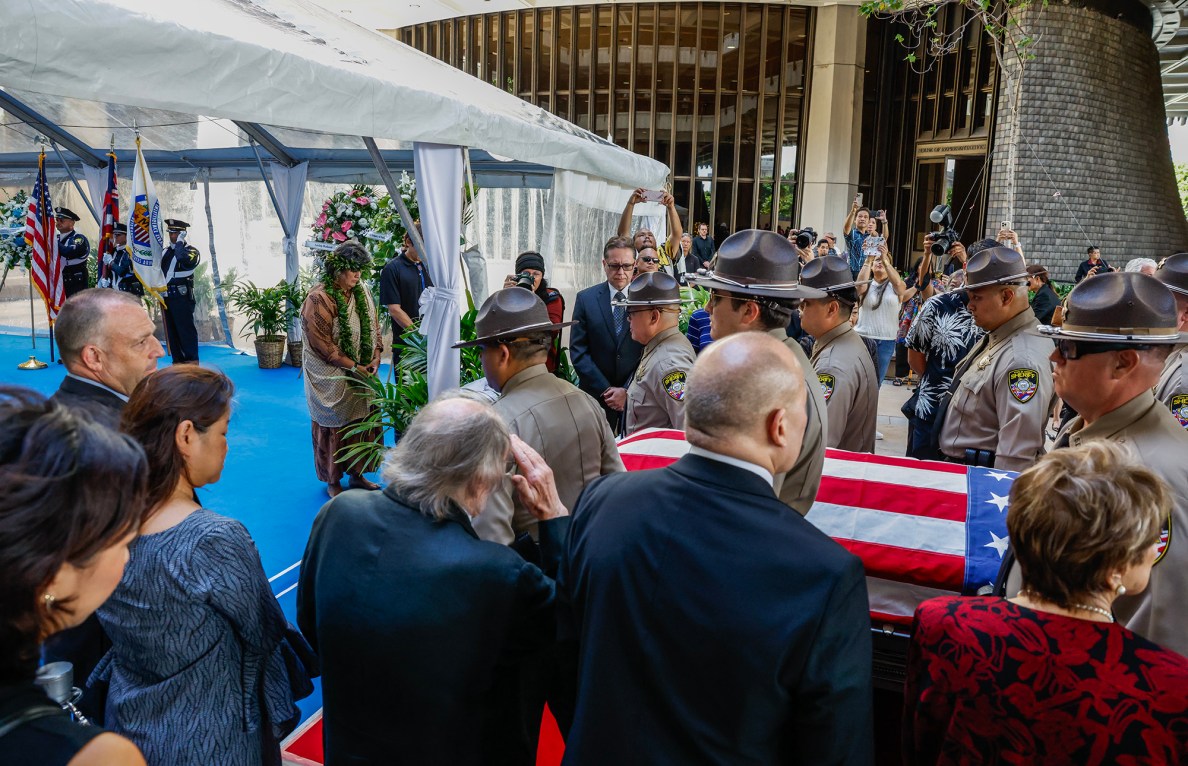 From left, Hawaiʻi Governor Josh Green, First Lady Jaime Kanani Green, former Hawaiʻi Governor Neil Abercrombie, Chief Justice Vladimir P. Devens, and Senator Lorraine Inouye stand with participants as the casket of former Hawaiʻi Governor George Ariyoshi is carried by Hawaiʻi State Sheriffs, Friday, Sept. 18, 2026, in Honolulu. Ariyoshi’s casket will lie in state at the State Capitol rotunda through Saturday.  (Jamm Aquino/Civil Beat/2026)