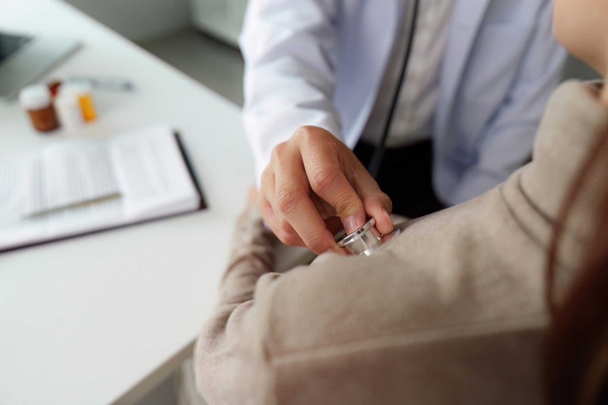 A healthcare professional conducts a thorough physical examination with the use of a stethoscope on a patient, fostering a supportive and caring environment.