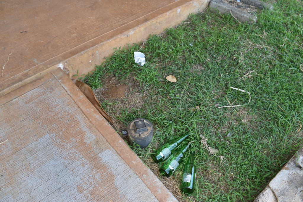 Three beer bottles lay on the lawn outside Kawailehua's community room. 