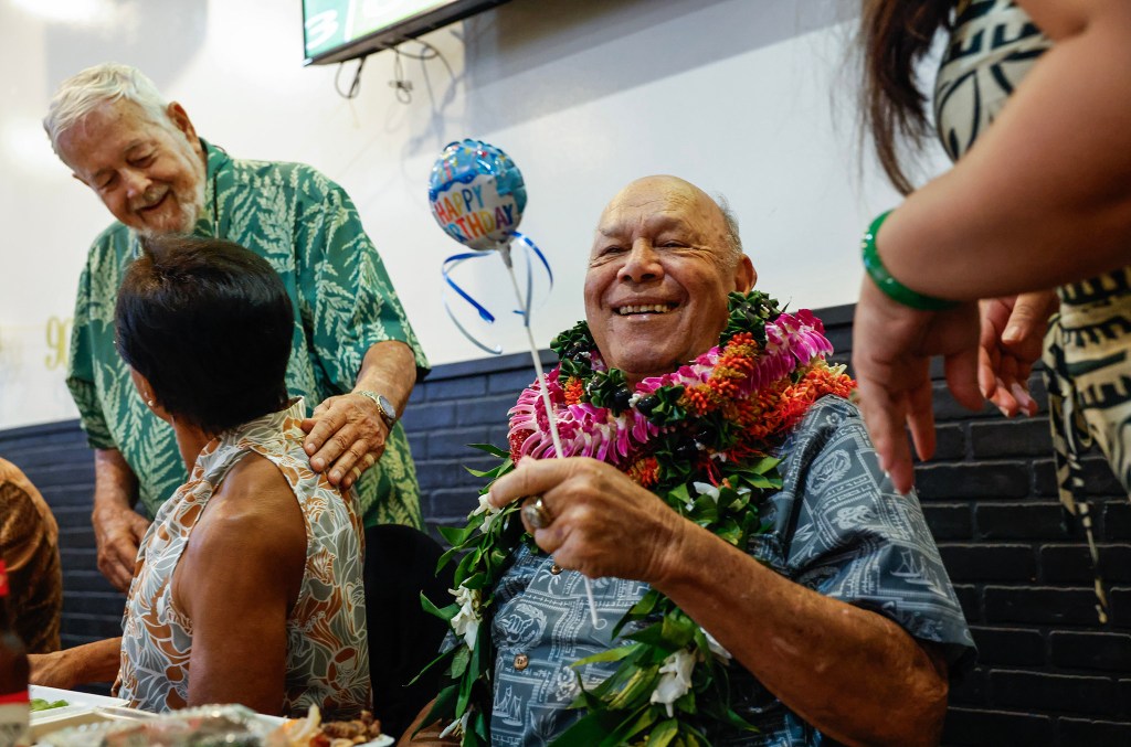 Francis Lum smiles while receiving a birthday balloon during his 90th birthday party celebration, Saturday, Oct. 3, 2026, in Kāneʻohe.. (Jamm Aquino/Civil Beat/2026)