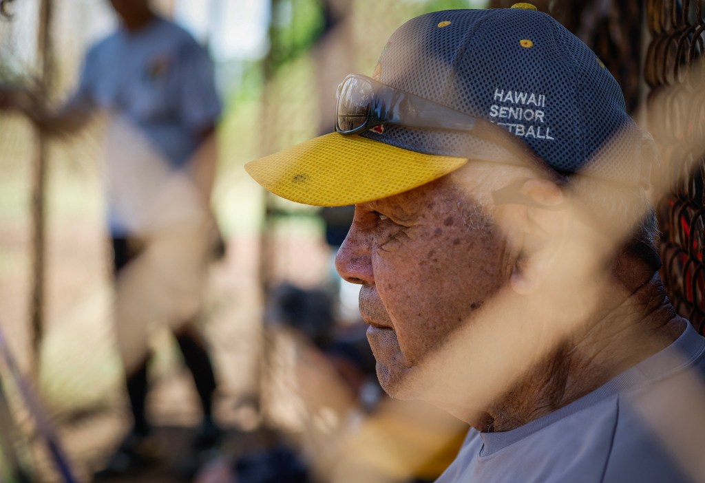 Francis Lum watches from the dugout during a softball game, Monday, Oct. 5, 2026, in Mōʻiliʻili. Lum plays three times a week along with batting practice on Tuesdays.  (Jamm Aquino/Civil Beat/2026)