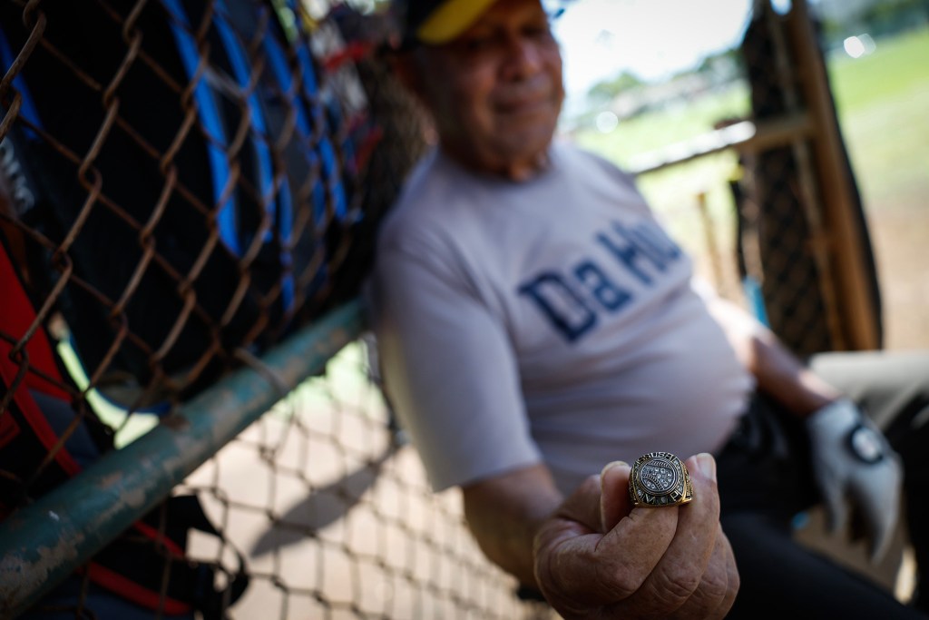 Francis Lum shows an MVP ring presented to him by UH coach John Nakamura that he always carries in his bat bag during a softball game, Monday, Oct. 5, 2026, in Mōʻiliʻili. Lum plays three times a week along with batting practice on Tuesdays.  (Jamm Aquino/Civil Beat/2026)