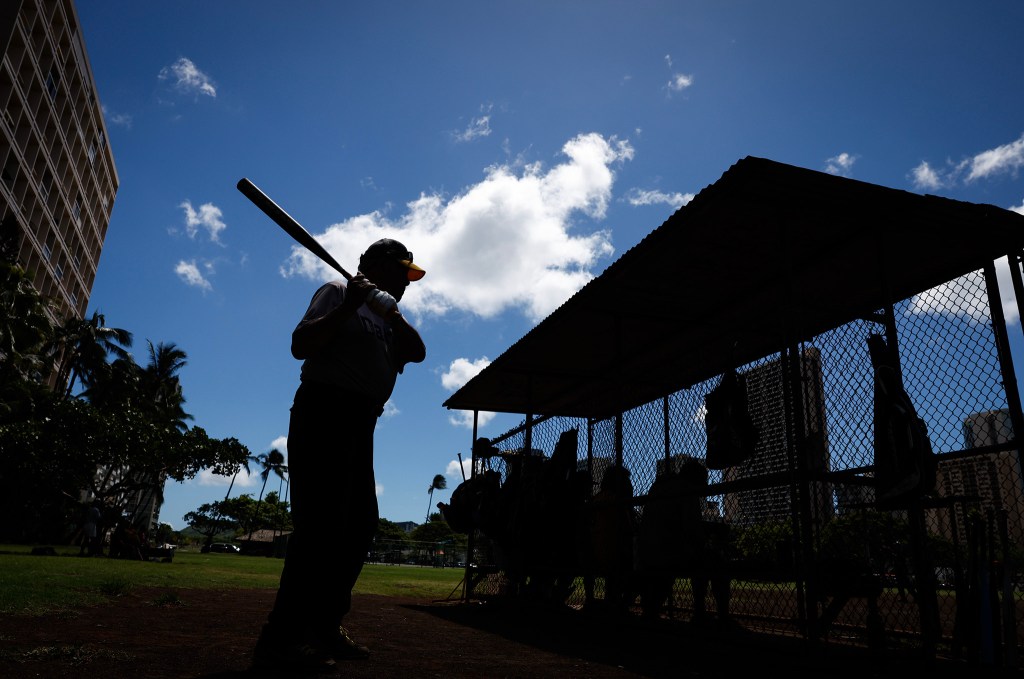 Francis Lum warms up on deck prior to his at-bat during a softball game, Monday, Oct. 5, 2026, in Mōʻiliʻili. Lum plays three times a week along with batting practice on Tuesdays.  (Jamm Aquino/Civil Beat/2026)
