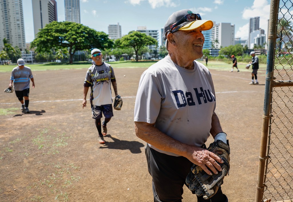 Francis Lum returns to the dugout with team mates at the end of the inning during a softball game, Monday, Oct. 5, 2026, in Mōʻiliʻili. Lum plays three times a week along with batting practice on Tuesdays.  (Jamm Aquino/Civil Beat/2026)