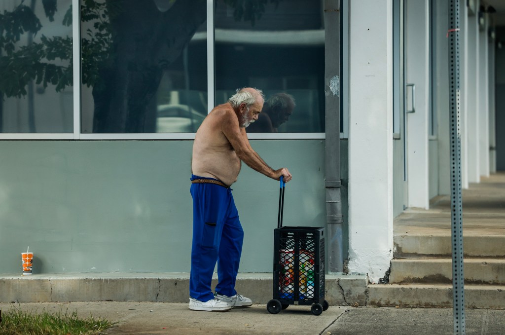 A kūpuna pushes his groceries while walking without his shirt along South King Street,  Monday, Oct. 26, 2026, in Honolulu. (Jamm Aquino/Civil Beat/2026)